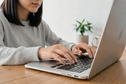 Femme utilisant la touche Shift sur un clavier Mac dans un bureau à domicile moderne